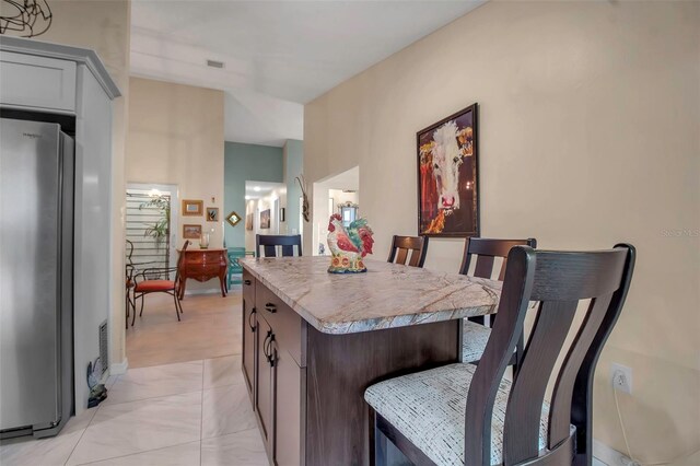 3410 Avenida Madera Unit B, Bradenton, FL 34210 - kitchen featuring freestanding refrigerator, a breakfast bar, a kitchen island, and light countertops