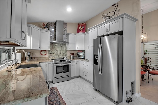 kitchen featuring sink, wall chimney exhaust hood, tasteful backsplash, light stone counters, and stainless steel appliances