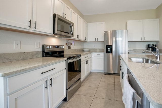 kitchen featuring white cabinetry, sink, light stone counters, and stainless steel appliances