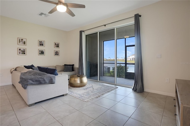 living room with a water view, light tile patterned floors, and ceiling fan