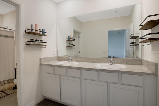 bathroom with curtained shower, vanity, and tile patterned floors