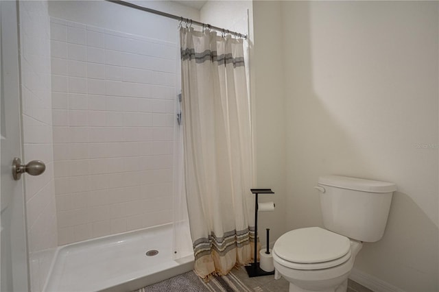 bathroom featuring walk in shower and toilet