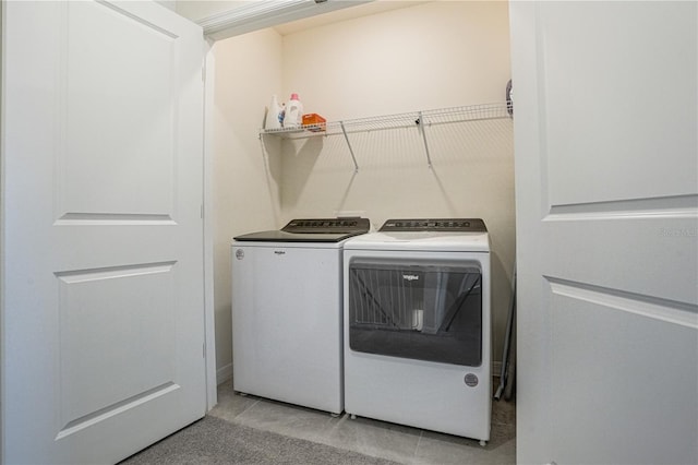 laundry room with light tile patterned floors and washing machine and clothes dryer