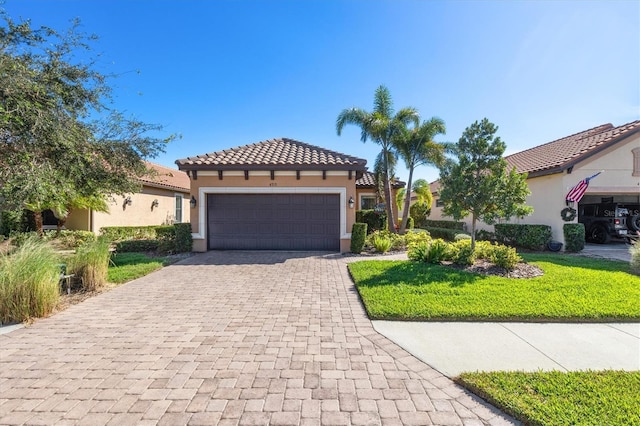 mediterranean / spanish house featuring a garage and a front lawn