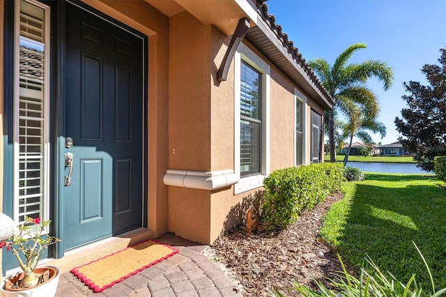 property entrance featuring a lawn