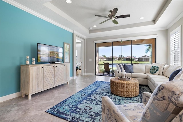 living room featuring ceiling fan, a raised ceiling, crown molding, a textured ceiling, and light tile patterned flooring