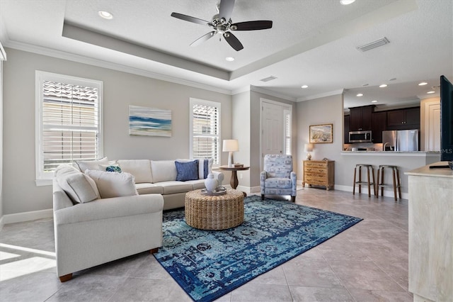 living room featuring light tile patterned floors, a textured ceiling, ceiling fan, and crown molding