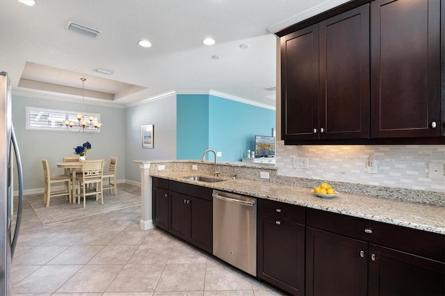 kitchen with appliances with stainless steel finishes, backsplash, dark brown cabinets, sink, and pendant lighting