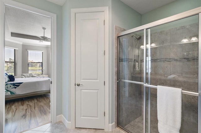 bathroom featuring tile patterned flooring, ceiling fan, and a shower with door