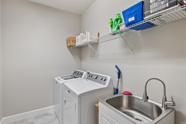 clothes washing area featuring washer and dryer, light tile patterned floors, and sink