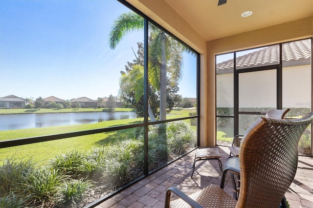 sunroom featuring a water view