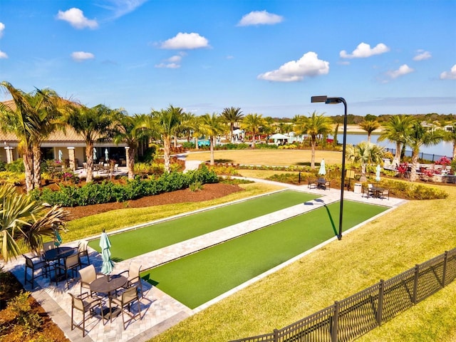 view of property's community with a lawn and a water view