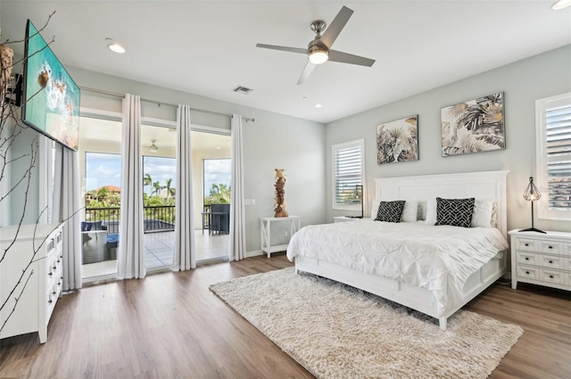 bedroom featuring dark wood-type flooring, multiple windows, ceiling fan, and access to exterior