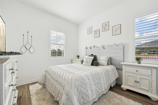 bedroom with dark wood-type flooring and multiple windows