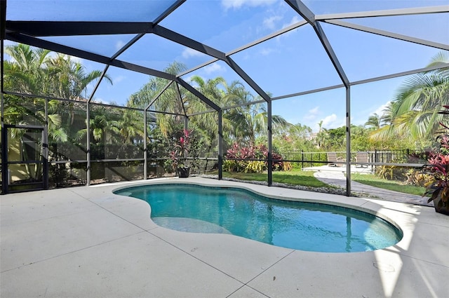 view of pool featuring glass enclosure and a patio area