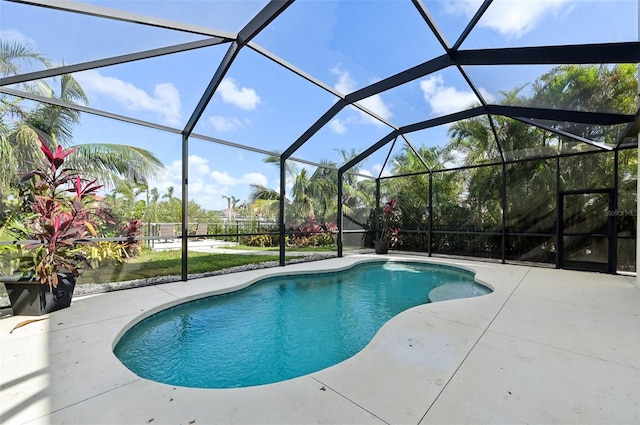 view of swimming pool with glass enclosure and a patio