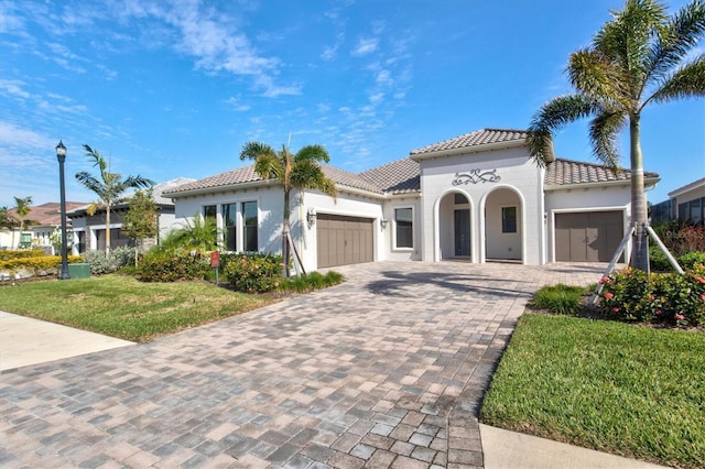 mediterranean / spanish-style home with a front yard and a garage