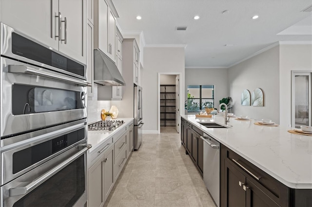 kitchen featuring sink, light stone countertops, ornamental molding, dark brown cabinets, and stainless steel appliances