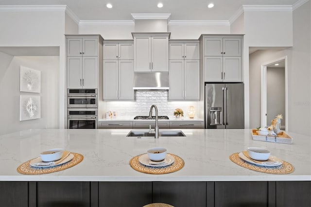 kitchen with light stone countertops, sink, stainless steel appliances, and exhaust hood