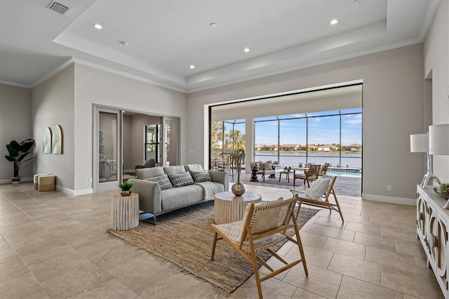 living room with a raised ceiling, crown molding, and a water view