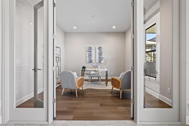 living area with light hardwood / wood-style floors and french doors