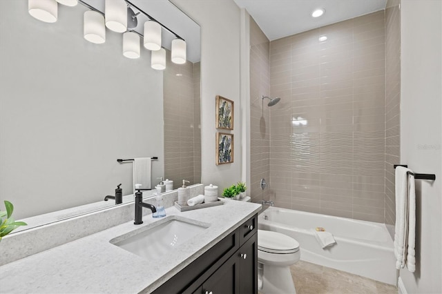 full bathroom with tile patterned flooring, vanity, tiled shower / bath combo, and toilet