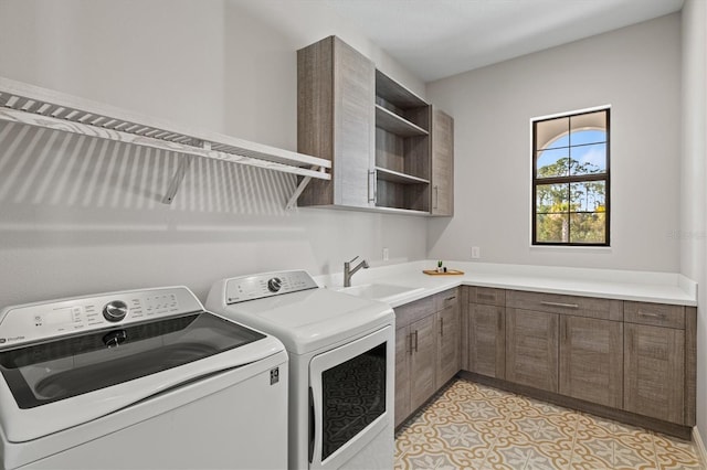 washroom featuring cabinets, washing machine and dryer, light tile patterned flooring, and sink