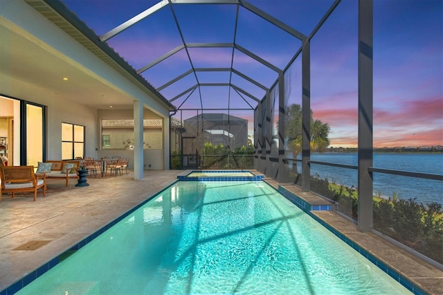 pool at dusk with a water view, an outdoor hangout area, a lanai, an in ground hot tub, and a patio area