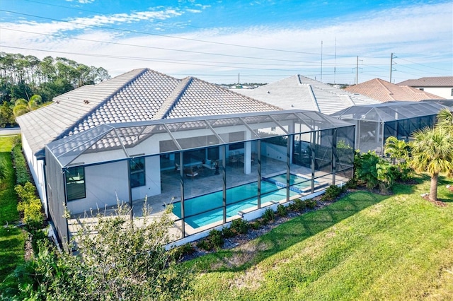 rear view of house with a yard, a patio, and a lanai