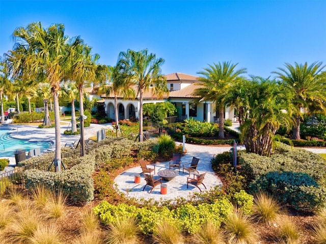 exterior space with a patio area, an outdoor fire pit, and a community pool