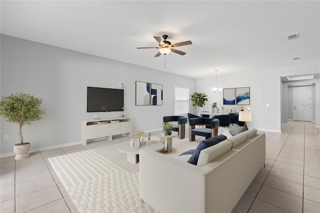 tiled living room featuring ceiling fan with notable chandelier