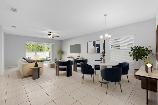 dining room featuring light tile patterned floors and ceiling fan with notable chandelier