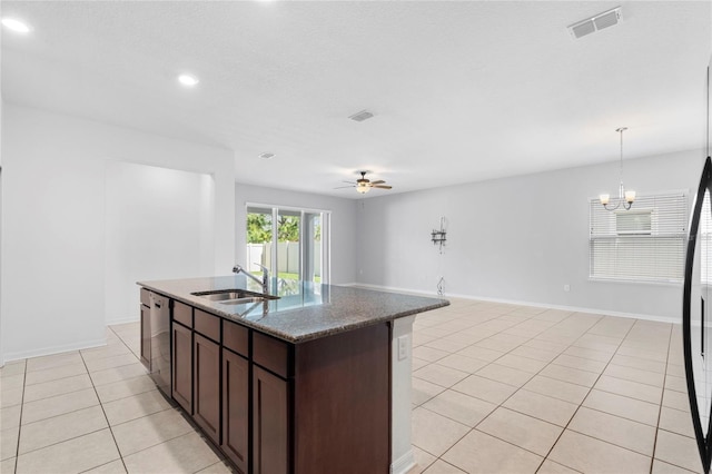 kitchen with dishwasher, stone counters, hanging light fixtures, sink, and dark brown cabinets