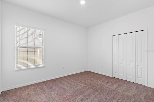 unfurnished bedroom featuring carpet flooring and a closet