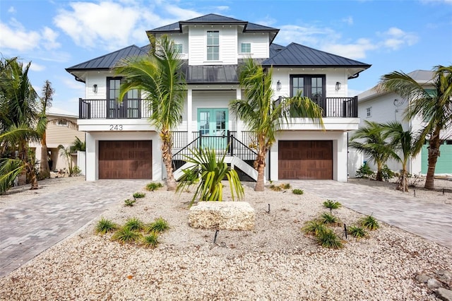 243 S Harbor Dr, Holmes Beach, FL 34217 - coastal home with french doors, a standing seam roof, an attached garage, and stairs