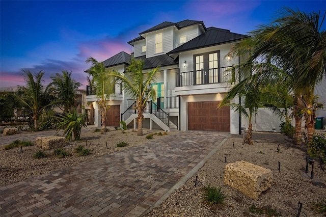 view of front of home with a porch, a garage, and french doors