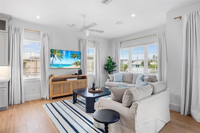 living room featuring ceiling fan and light hardwood / wood-style floors