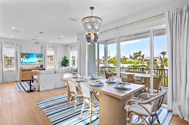 dining area with plenty of natural light, a chandelier, and light hardwood / wood-style flooring