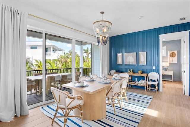 dining space with light wood-type flooring and an inviting chandelier