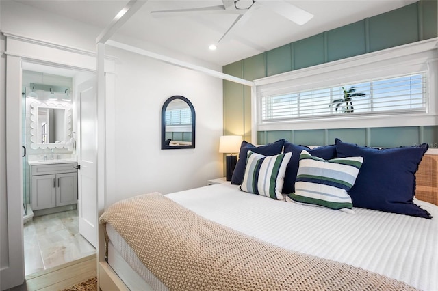 bedroom with multiple windows, ensuite bath, ceiling fan, and sink