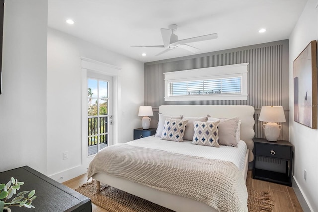 bedroom with ceiling fan, wood-type flooring, and multiple windows