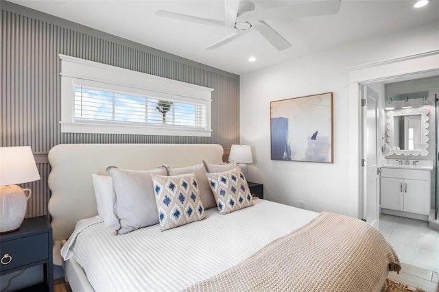 bedroom featuring connected bathroom, ceiling fan, and sink