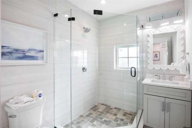 bathroom featuring vanity, toilet, and a shower with shower door