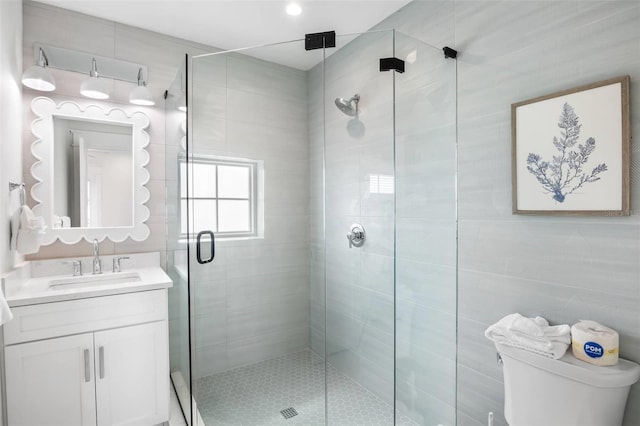 bathroom with an enclosed shower, vanity, and toilet