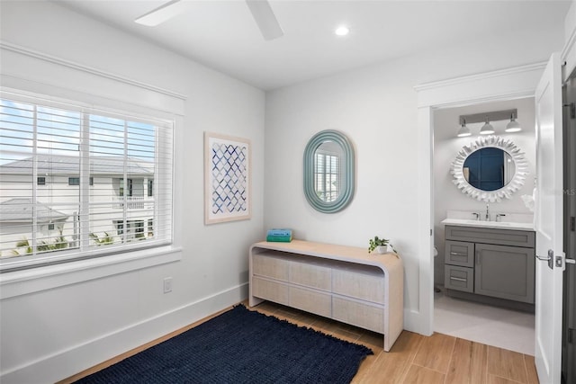 bedroom with light hardwood / wood-style floors, ceiling fan, and sink