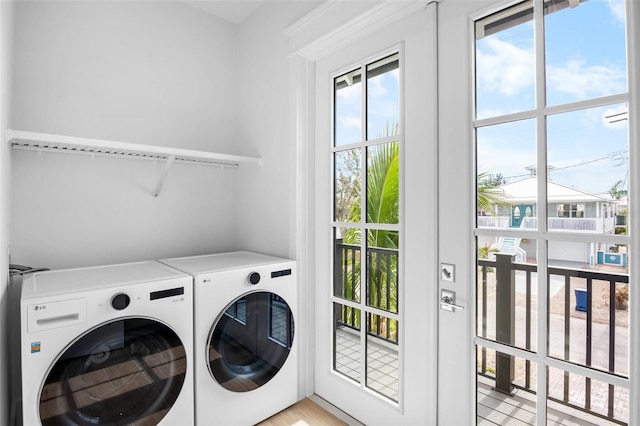 clothes washing area with light hardwood / wood-style floors and washing machine and clothes dryer