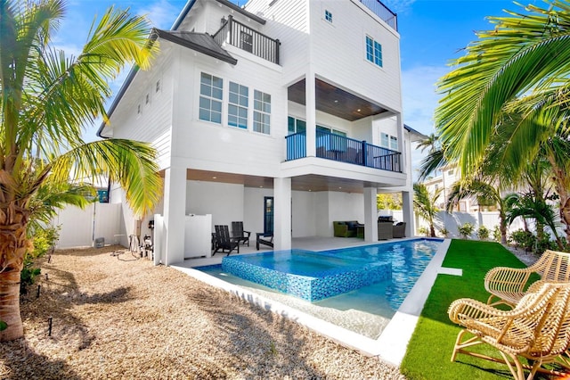 back of house with a patio area, a balcony, and a fenced in pool