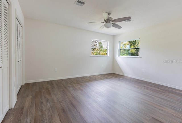 unfurnished bedroom featuring ceiling fan and dark hardwood / wood-style flooring