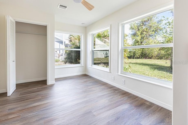 unfurnished sunroom with ceiling fan