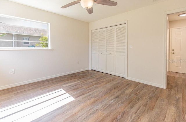 unfurnished bedroom featuring light wood-type flooring, ceiling fan, and a closet